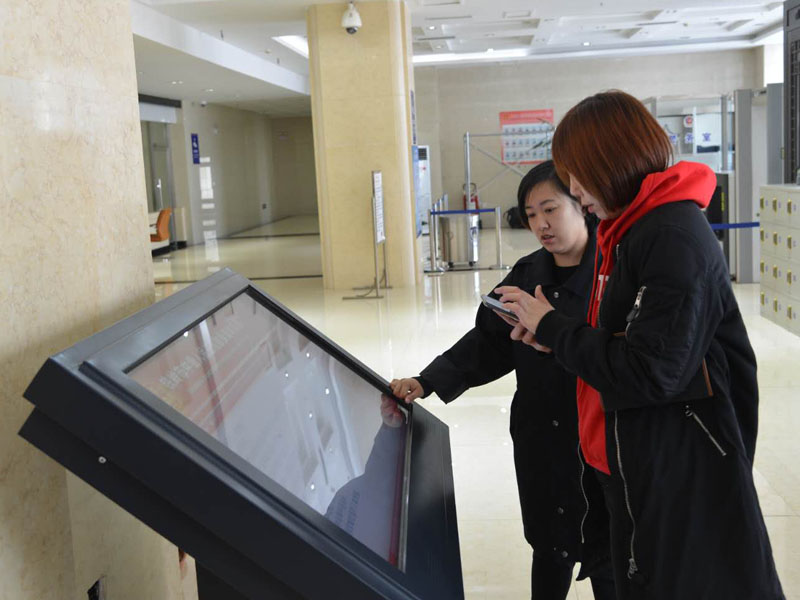 圖三，赫媛媛向記者介紹自助查詢機(jī)