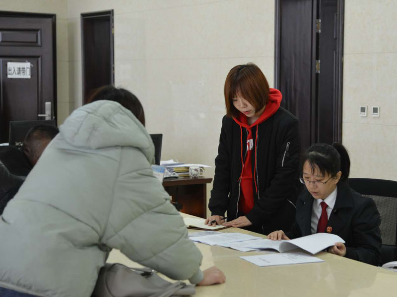 圖四，記者和劉璐一起在立案窗口接待辦事人