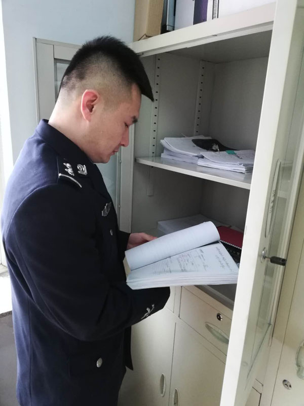 圖二，辛楊查閱卷宗，在一摞摞卷宗材料中尋找線索