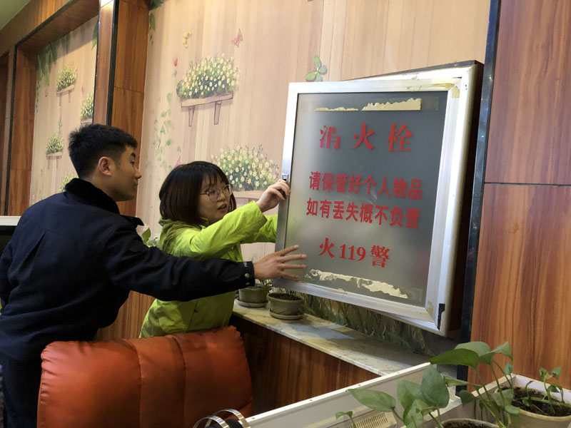 (圖三)民警指導(dǎo)記者檢查網(wǎng)吧消防栓