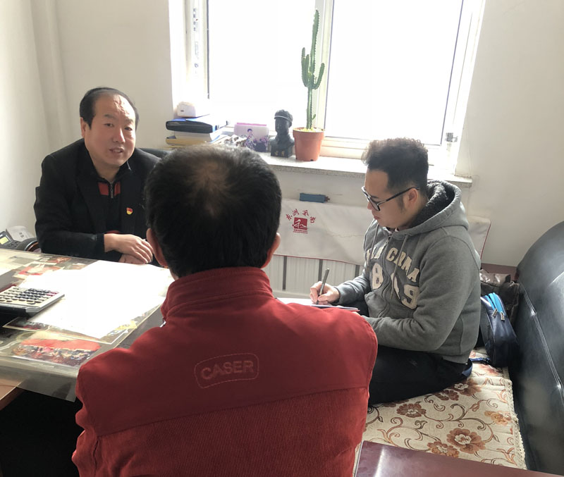 記者(右一)與馬慶國(guó)(左一)一起與社區(qū)居民聊天