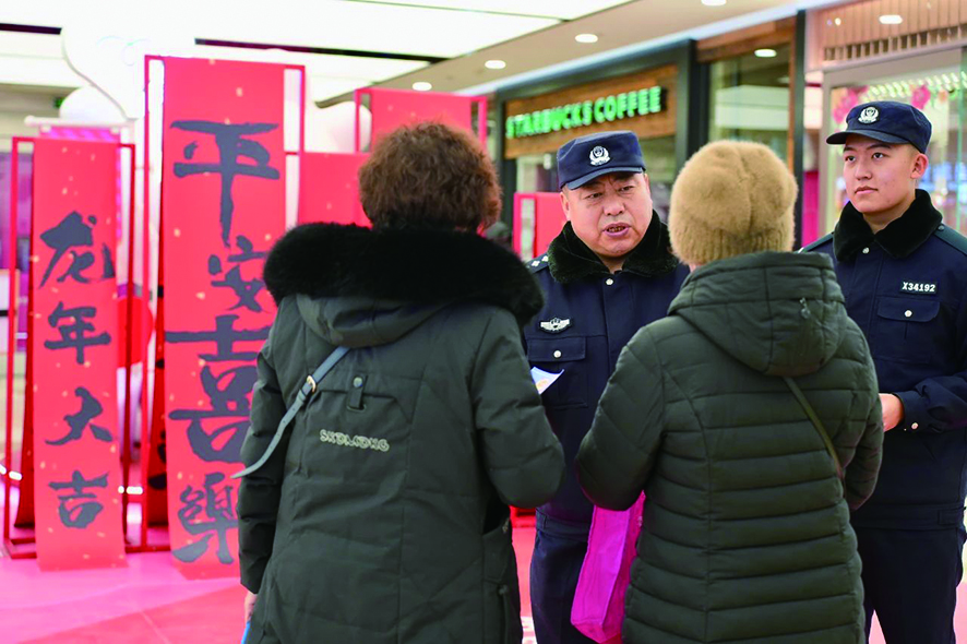 春節(jié)期間,民警老徐(左二)囑咐群眾要防范電信詐騙