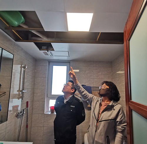 和平區(qū)法院執(zhí)行法官劉訓(xùn)兵(左)在申請執(zhí)行人家中查看漏水情況 劉鑫宇攝