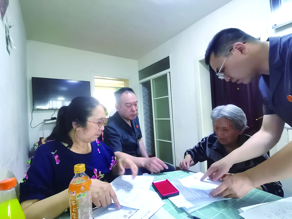 付承志（右一）胡善福（左二）指導(dǎo)潘某榮（右二）在調(diào)解書上簽字、按手印