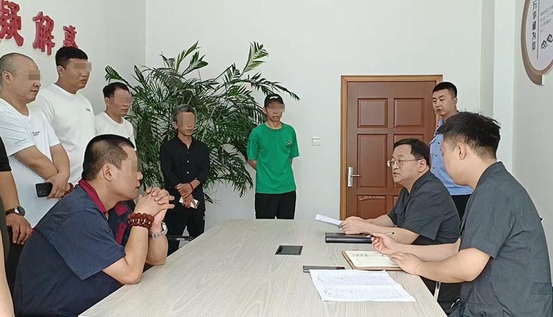新民市法院執(zhí)行局局長王旌棘（右3）向農(nóng)民工們了解案情（所有不穿法服和警服的人，都需要馬賽克!）