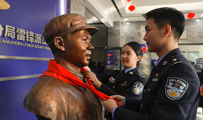 2024年3月5日，撫順市公安局望花分局雷鋒派出所民警白靜（右）和長沙市公安局雷鋒派出所民警韓政霖（左）共同為雷鋒塑像整理紅領巾。