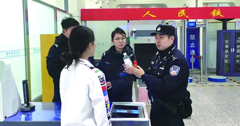 二題圖，童秋華（右）在向旅客講解安檢規(guī)定