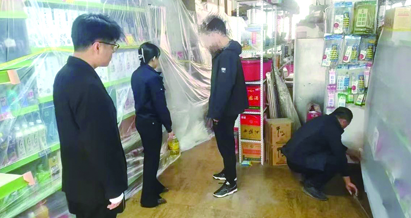 二圖，法院干警正在幫助一樓商戶粘貼防塵塑料布