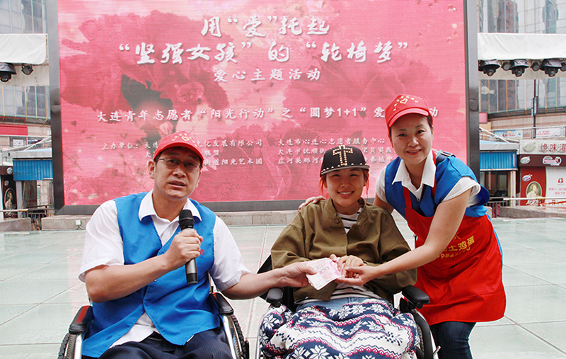 韓偉(左一)與愛人陶陸幫助重度殘疾人實(shí)現(xiàn)“輪椅夢”愛心愿望