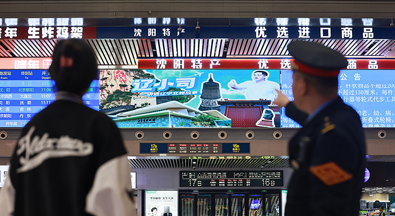 沈陽(yáng)站候車(chē)大廳，旅客和乘警一起觀看“遼小司”視頻。 本報(bào)記者 孟浩 攝
