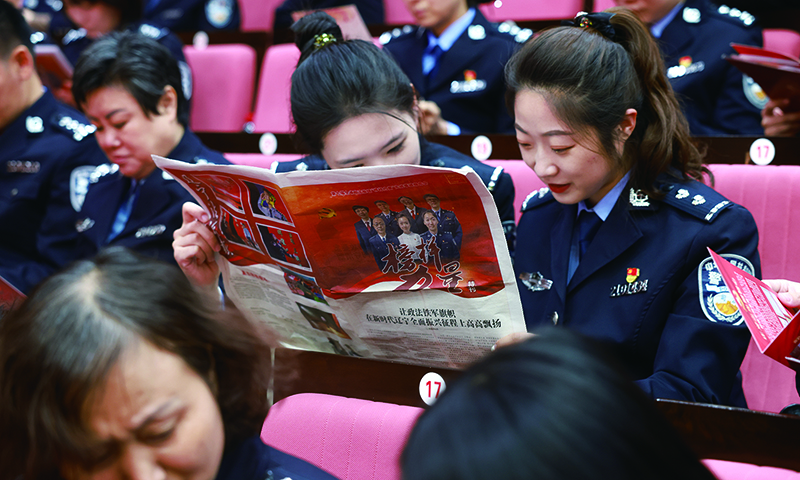政法干警仔細翻閱《榜樣力量》特刊
