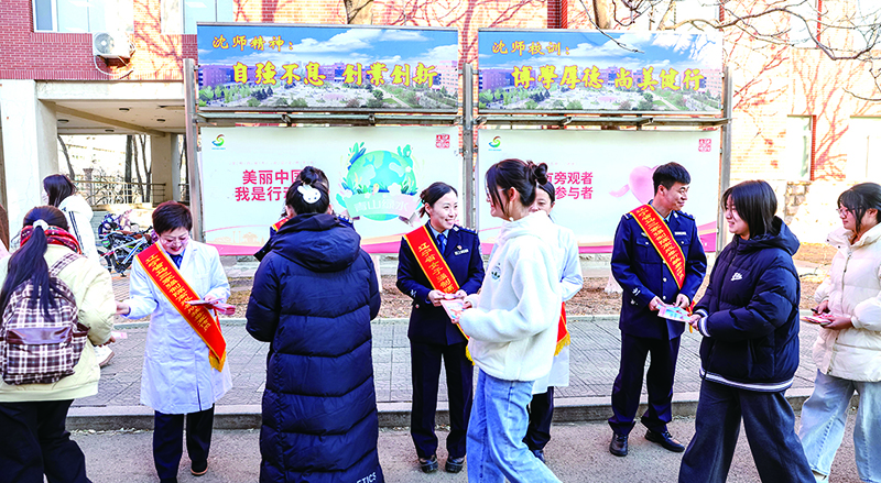 頭題圖，戒毒干警在沈陽師范大學(xué)校園發(fā)放宣傳單。