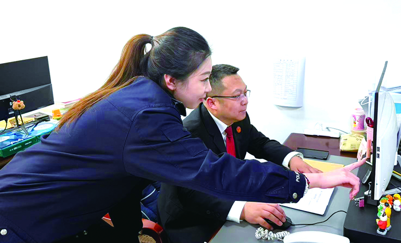 執(zhí)行指揮中心副主任姜浩（右）指導(dǎo)執(zhí)行局干警辦案